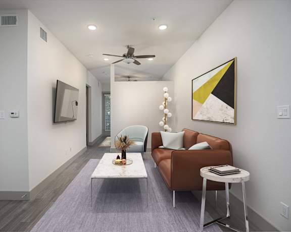 a living room with white walls and a brown couch and a coffee table
