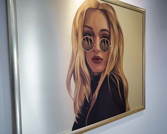 A woman with sunglasses is reflected in a mirror.