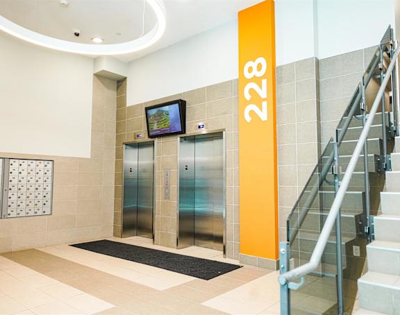 the lobby of a building with two elevators and a staircase