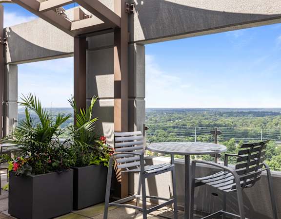 A patio with a table and chairs overlooking a valley at Clayton on the Park Apartments, Clayton, Missouri