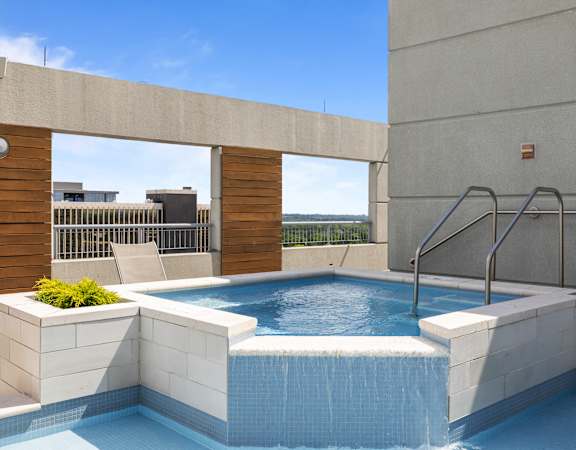 A small pool with a waterfall feature in the middle of it at Clayton on the Park Apartments, Clayton, Missouri