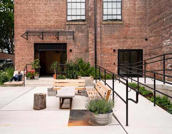 A courtyard with a bench, a table and a planter.