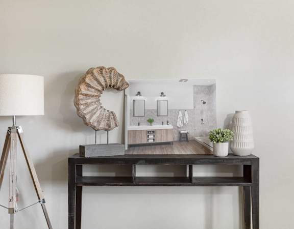A table with a lamp, a plant, and a model of a house.