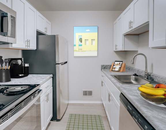 A kitchen with a black stove top oven and white cabinets.