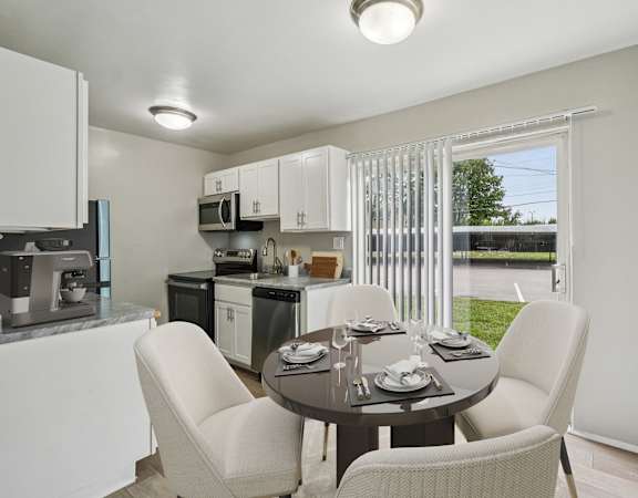 A modern kitchen with a dining table set for four.