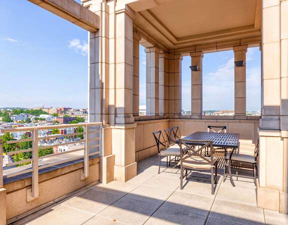 a balcony with a table and chairs and a view of the city