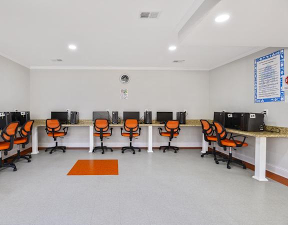 A room with white walls and orange chairs.