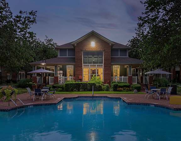 Resort-style swimming pool at dusk - Belle Harbour Apartments