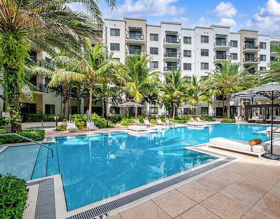 Resort-style swimming pool with sunning deck - The Remy Apartments