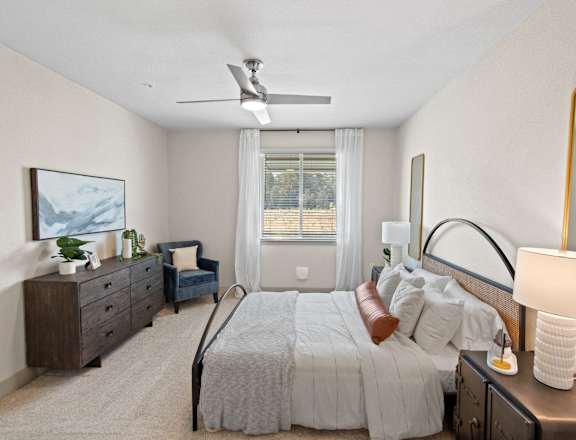 a bedroom with a large bed and a ceiling fan