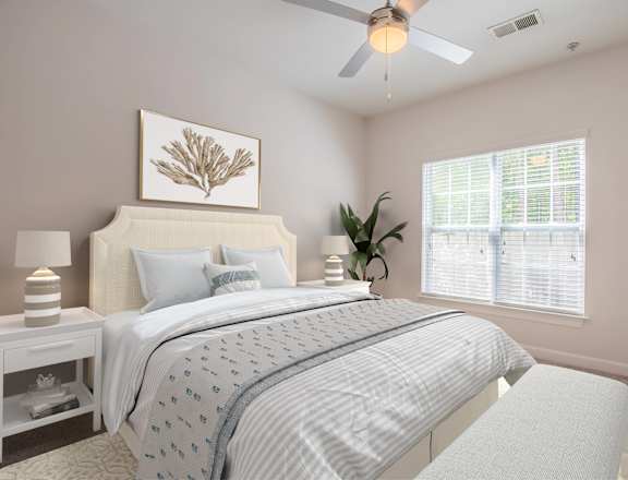 A bedroom with a bed, nightstands, and a ceiling fan.