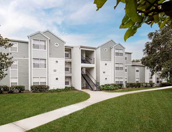 A modern apartment complex with a green lawn in front.