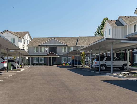 A parking lot with cars and a building in the background at Cascade Place Apartment Homes, Molalla, OR, 97038