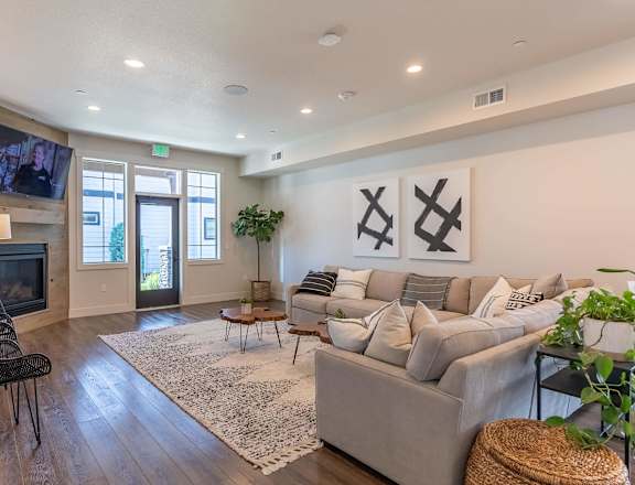 A living room with a grey couch, a television, and a rug at Timberridge Place Apartment Homes, Albany, 97322