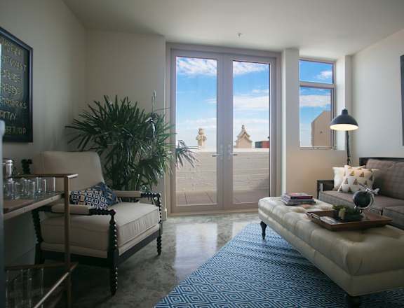 a living room with a view of the beach and a couch and chair at Garment Lofts, California