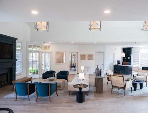 A living room with a fireplace and blue chairs.