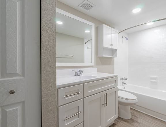 A white bathroom with a toilet, sink, and bathtub. at Imperial Gardens Apartments, Clearwater, FL, 33764