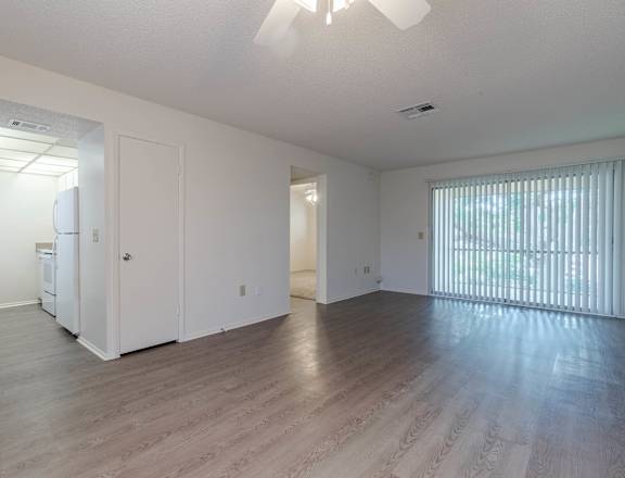 A spacious room with a ceiling fan and wooden flooring. at Imperial Gardens Apartments, Clearwater, FL, 33764