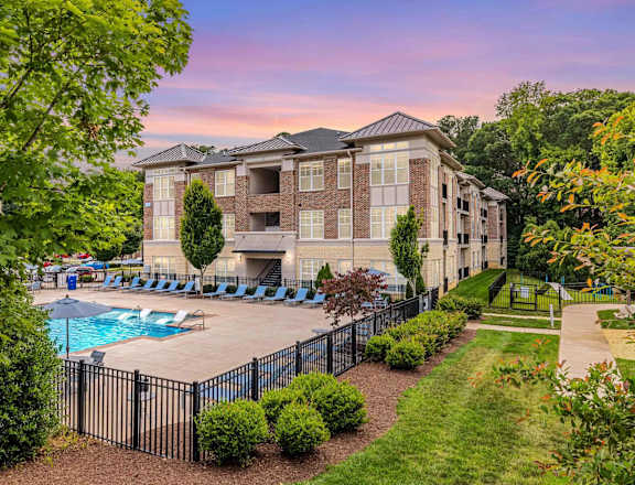 A large building with a pool in front of it.