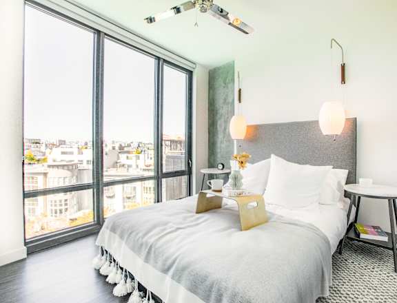 A bedroom with a large bed and a view of the city.at The Rise, California
