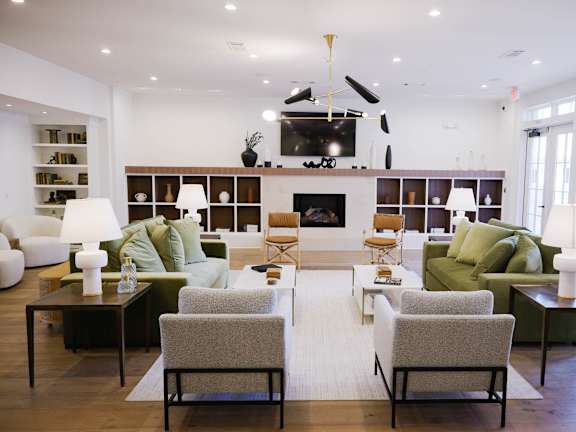 A living room with a fireplace and a green couch. at The Quarter Lofts Apartments, Mississippi, 39216