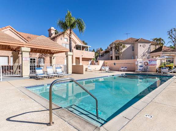 A swimming pool in a residential area with a house in the background. at Whispering Fountains Diamond Bar, Diamond Bar, CA