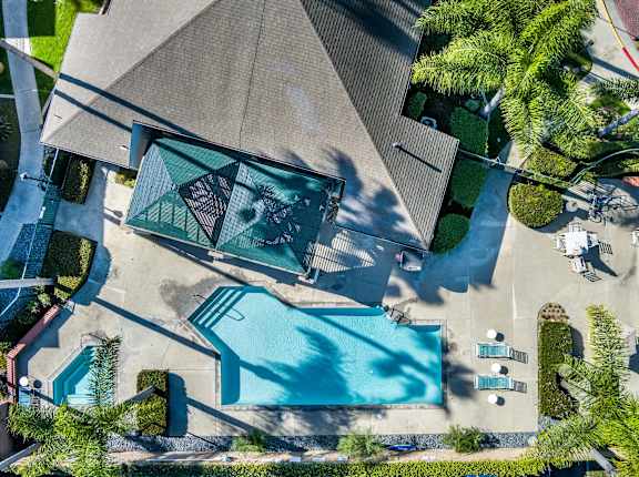 An aerial view of a house with a pool and a patio area. at Whispering Fountains Lakewood, Lakewood Bar California