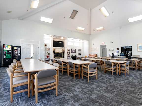 A room with tables and chairs and a vending machine. at Whispering Fountains Lakewood, Lakewood Bar