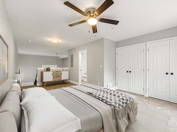 A bedroom with a bed, dresser, and wardrobe at Crogman School Lofts in Atlanta, GA