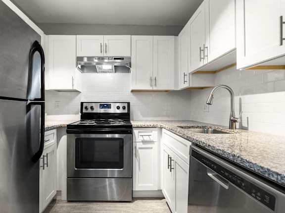 a kitchen with stainless steel appliances and white cabinets  grass at Georgian Oaks Apartments in Smyrna, 30080