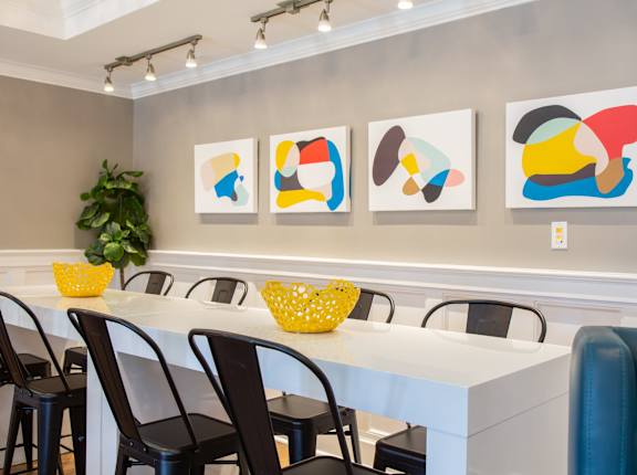 A dining room with a white table and chairs.
