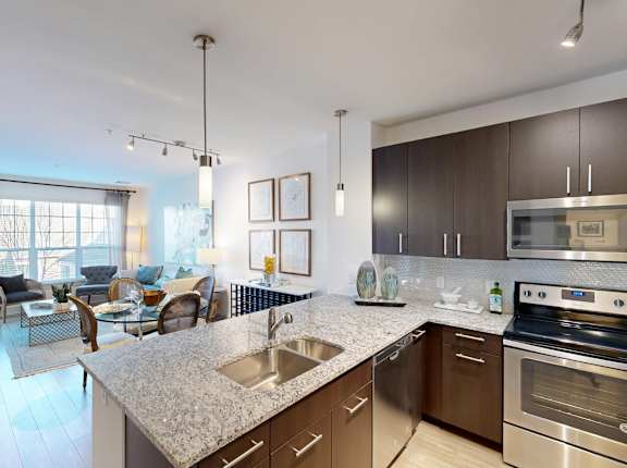 A modern kitchen with stainless steel appliances and a marble countertop.