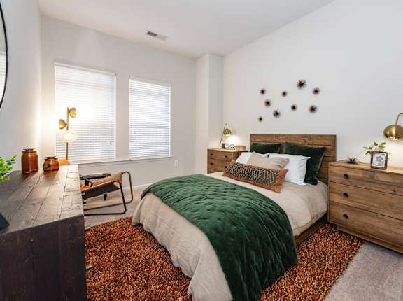 A bedroom with a bed, nightstand, and a chair.