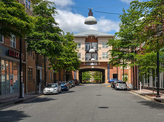 A street view with cars parked on the side and a building in the background.