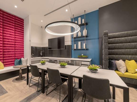 A modern dining room with a long table and grey chairs.