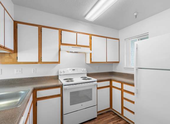 a kitchen with white appliances and wooden cabinets