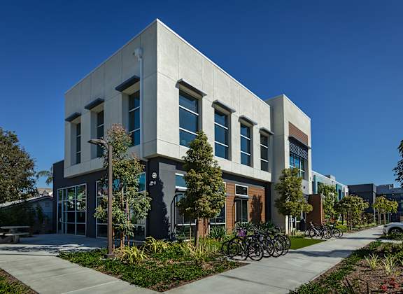 A modern building with a grey facade and a bicycle parked in front.