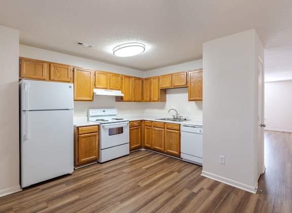 A kitchen with wooden cabinets and white appliances.at The Village at England Run, Virginia, 22406
