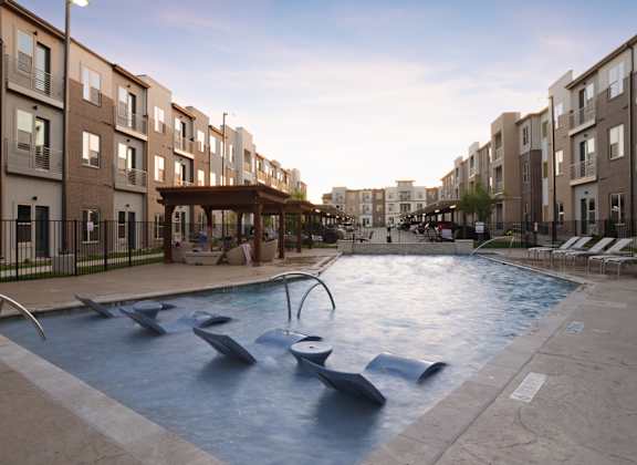 a large pool with chairs in an apartment building at Epic Apartments, Denton, TX, 76210
