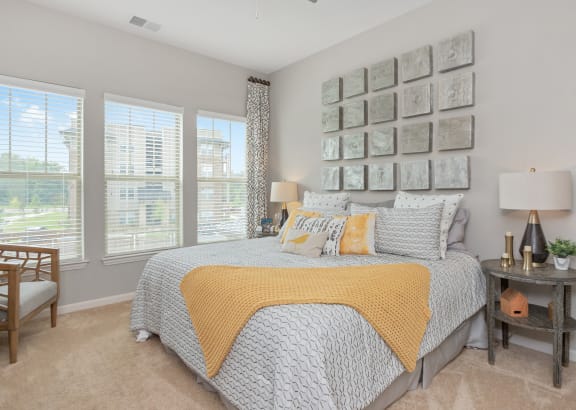 a bedroom with a bed and a wall of pictures on the wall above it at Residence at Riverwatch in Augusta, GA 30909