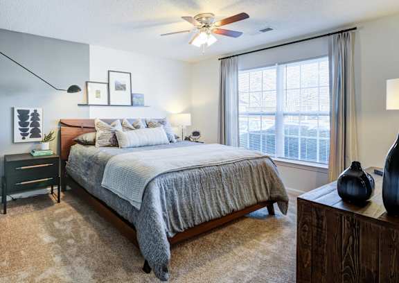 A bedroom with a bed, a dresser, and a mirror.