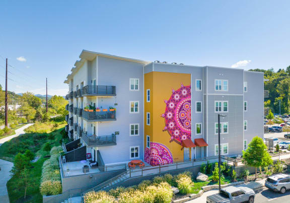 A modern apartment building with a large mural on the side at Skyloft in Asheville, NC
