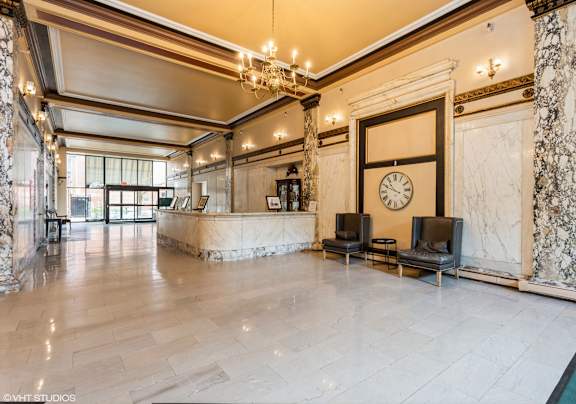 A large, elegant room with a marble floor and a clock on the wall at Mohican Apartments, New London, 06320