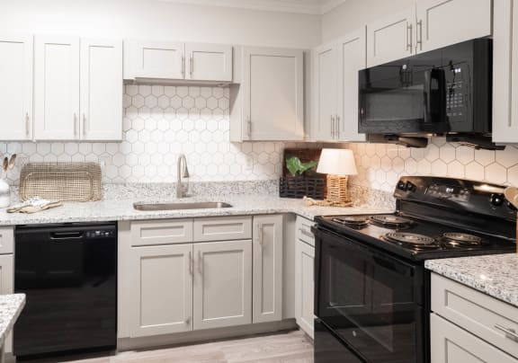 a kitchen with white cabinets and black appliances at Appling Lakes, Cordova, TN, 38016
