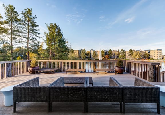 an aerial view of a house on a lake with mountains in the background at Apartments at Ashford Belmar Apartments, Colorado