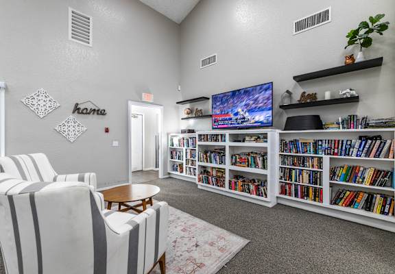 Clubroom with extensive built-in bookshelves at Whispering Fountains Riverside, Riverside