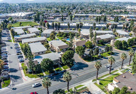A view of a residential area with houses and parked cars at Whispering Fountains Riverside, Riverside, CA, 92503