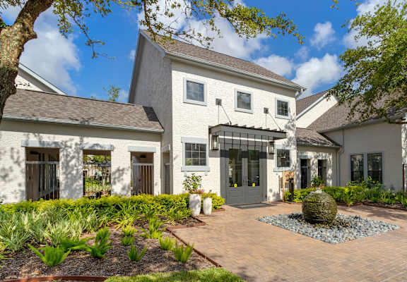 the front of a house with a brick walkway and a fountain at Summerwind in Pearland, Texas