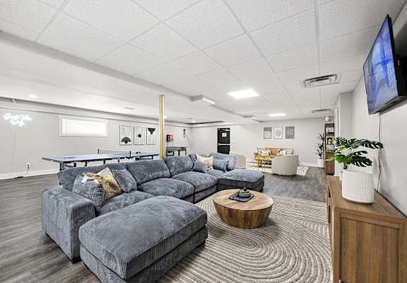 A living room with a grey sofa set and a television mounted on the wall at Gardens at Washington Park in Atlanta, Georgia, 30314