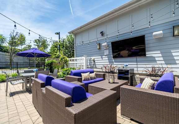 a patio with furniture and a television on the side of a house